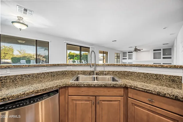 a kitchen with granite countertop a sink and a wooden floor