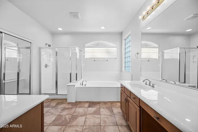 a spacious bathroom with a double vanity sink a mirror and a bathtub