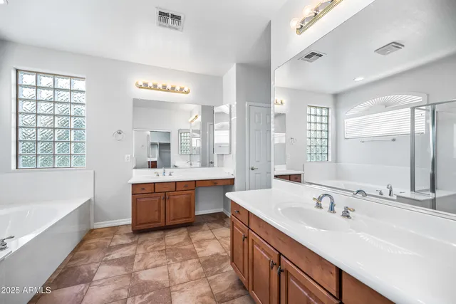 a bathroom with a granite countertop tub sink and mirror