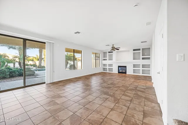 a view of an empty room with a fireplace and windows