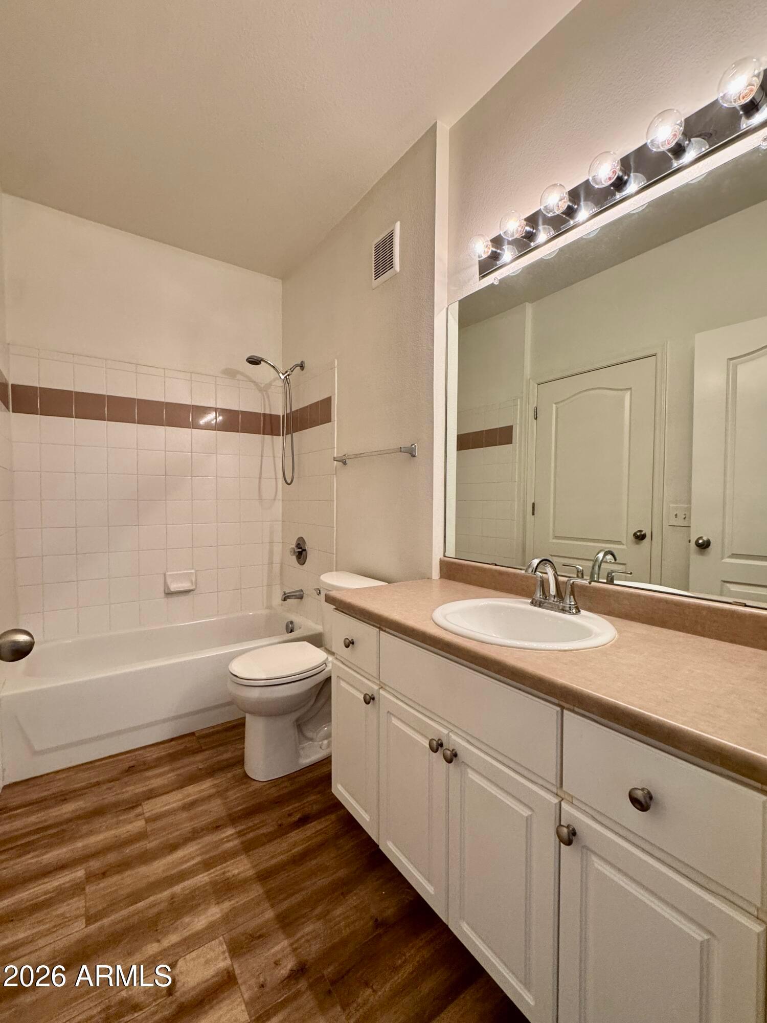 1701 East Colter Street, Unit 465 Phoenix, AZ 85016 - Photo 17 of 25 a bathroom with a granite countertop sink toilet a large mirror a bathtub and shower