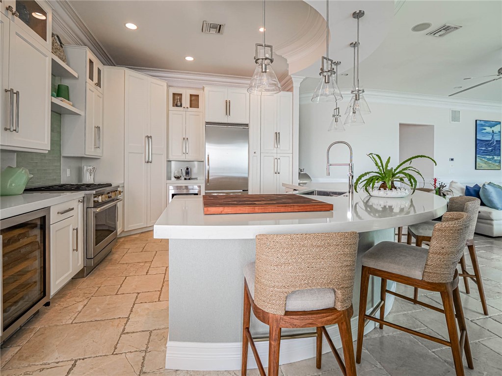 2250 Sanderling Lane Vero Beach, FL 32963 - Photo 12 of 36 a kitchen with stainless steel appliances kitchen island granite countertop a sink and a refrigerator