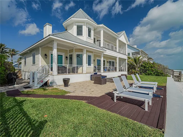 a view of a house with backyard sitting area and swimming pool
