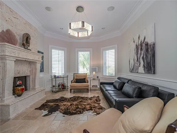 a living room with furniture a fireplace and a chandelier