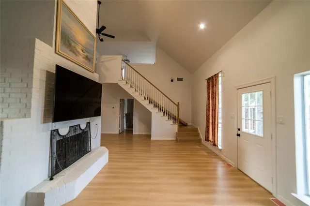 a view of a livingroom with wooden floor and a staircase