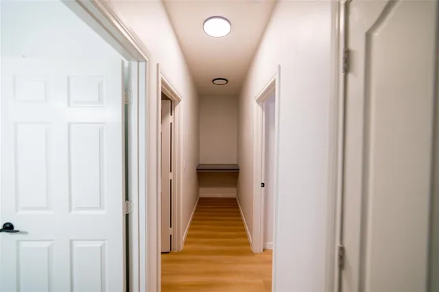 a view of a hallway with wooden floor and staircase