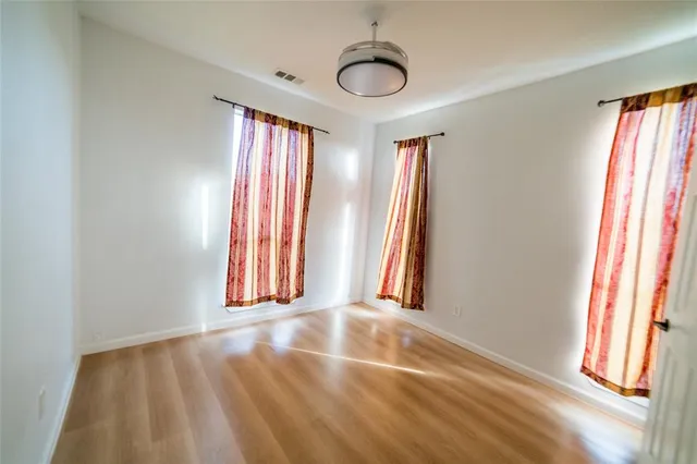 a view of hallway with window and wooden floor