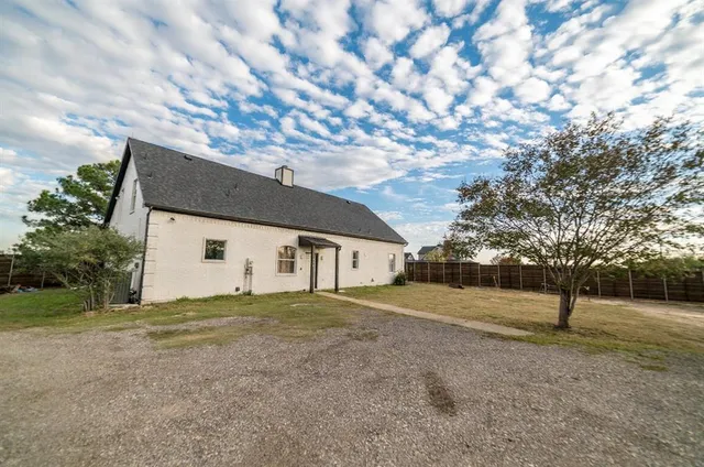 a view of a house with a tree and a yard