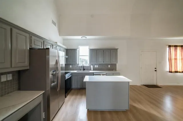 a kitchen with stainless steel appliances a refrigerator a sink a stove a microwave a counter space and cabinets