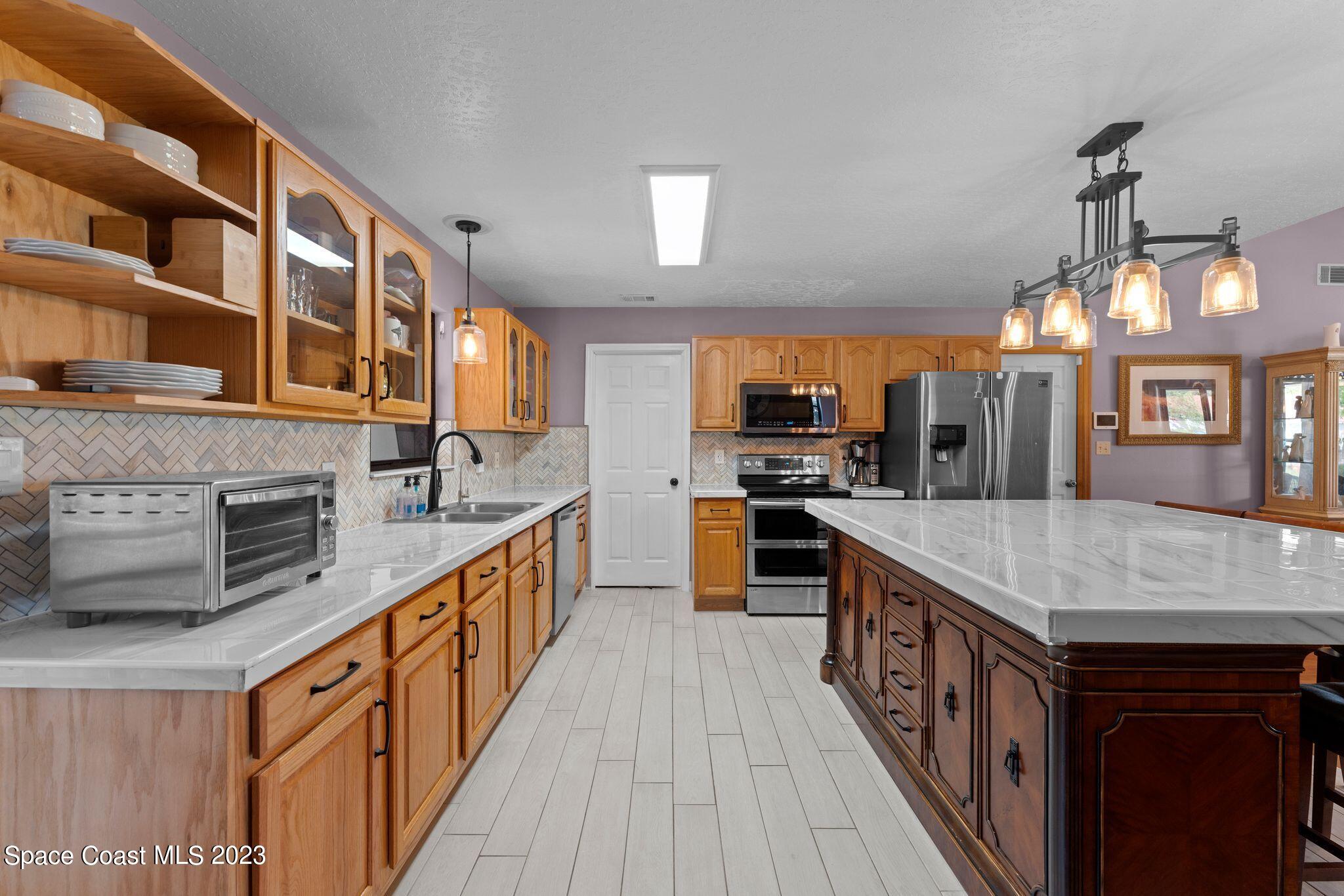 3704 Windsor Drive Cocoa, FL 32926 - Photo 11 of 48 a kitchen with stainless steel appliances granite countertop a kitchen island a stove and a sink