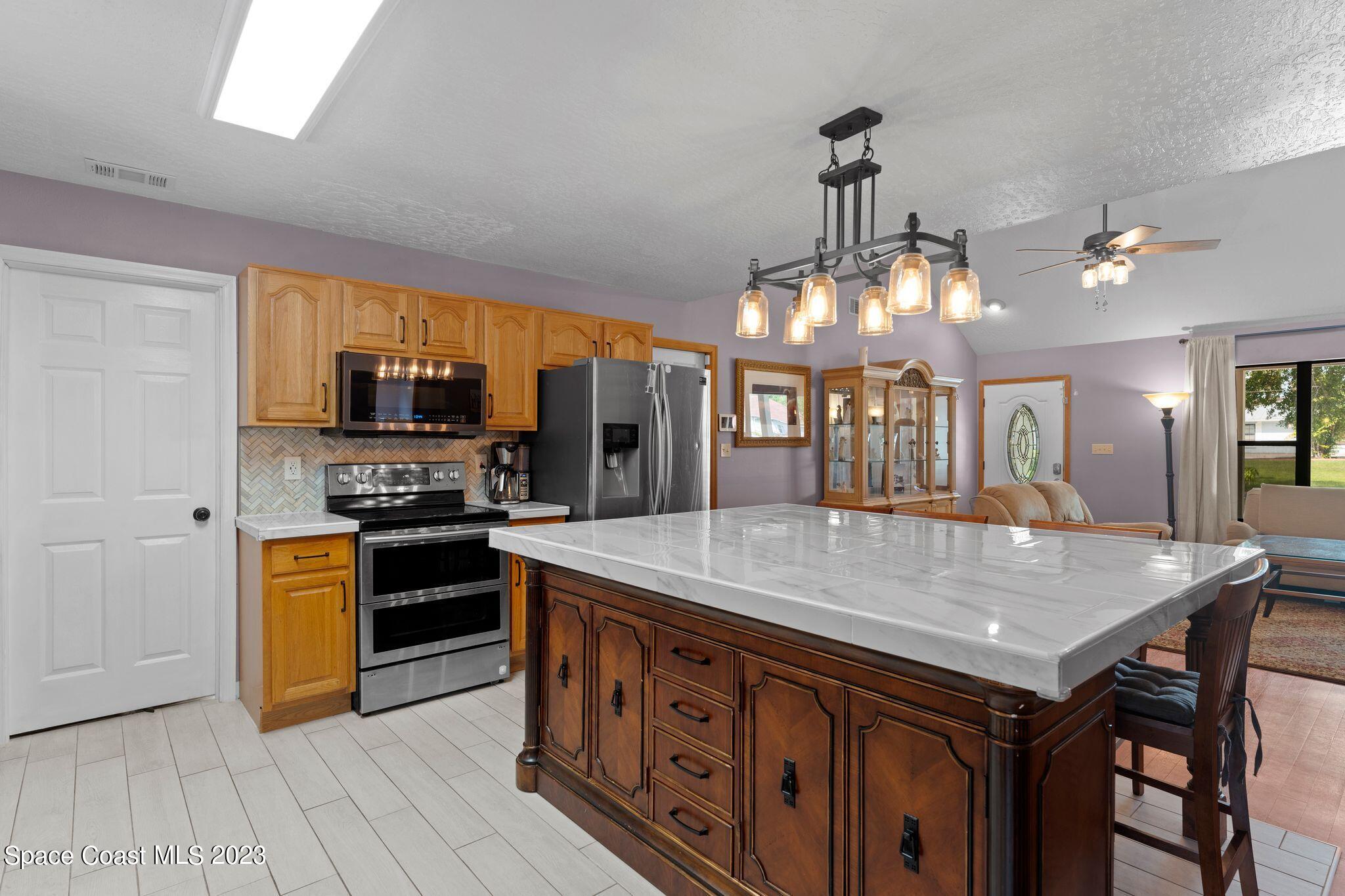 3704 Windsor Drive Cocoa, FL 32926 - Photo 13 of 48 a kitchen with stainless steel appliances granite countertop a kitchen island a stove and a sink