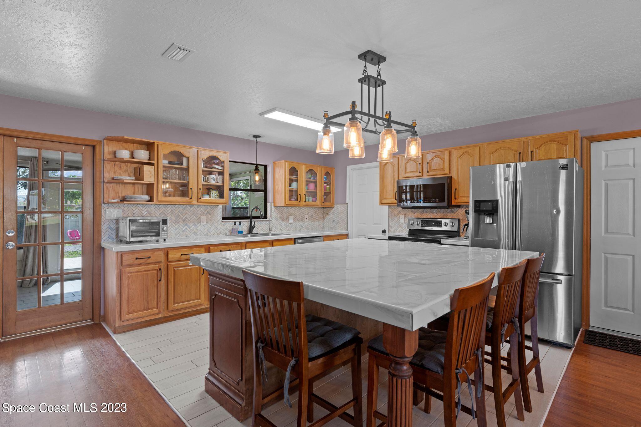 3704 Windsor Drive Cocoa, FL 32926 - Photo 7 of 48 a kitchen with stainless steel appliances granite countertop a kitchen island hardwood floor and a sink