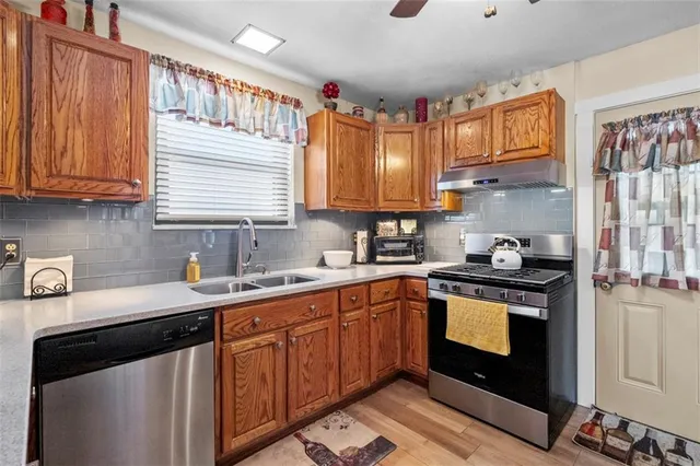 a kitchen with stainless steel appliances granite countertop a sink stove and cabinets
