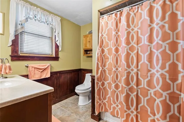 a bathroom with a sink a toilet and a mirror