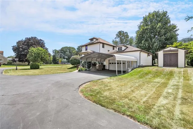 a view of a house with a big yard and large trees