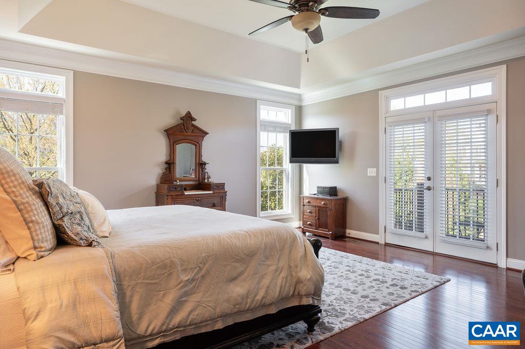 2706 Lockerbie Lane Keswick, VA 22947 - Photo 21 of 55 a bedroom with a bed and a chandelier with a flat tv screen