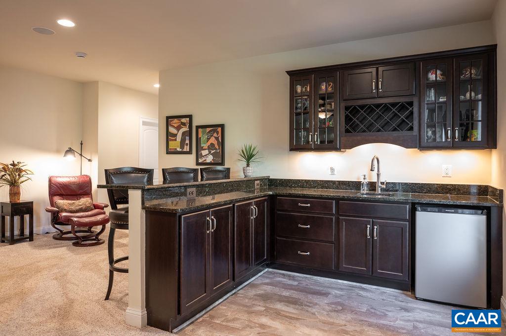 2706 Lockerbie Lane Keswick, VA 22947 - Photo 33 of 55 a kitchen with a sink and wooden cabinets