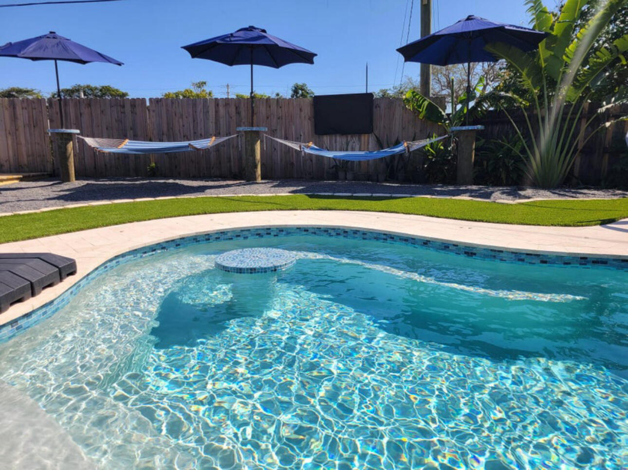 270 Northwest 36th Street Boca Raton, FL 33431 - Photo 11 of 82 a view of a swimming pool with a table and chairs under an umbrella