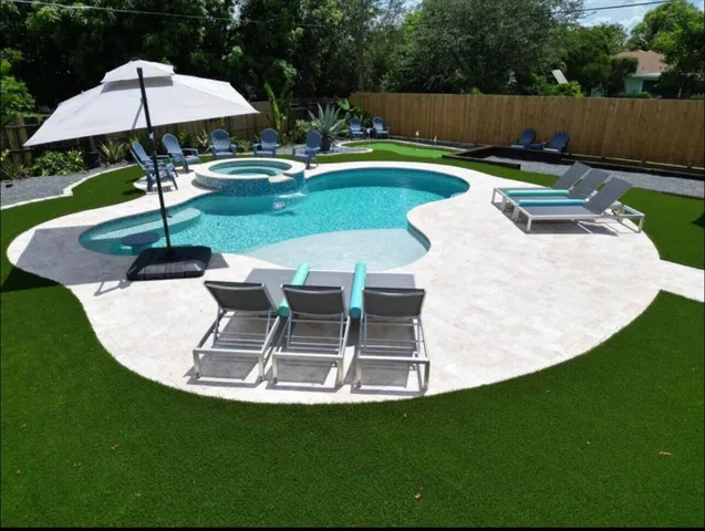 a swimming pool with lots of tress in front of it