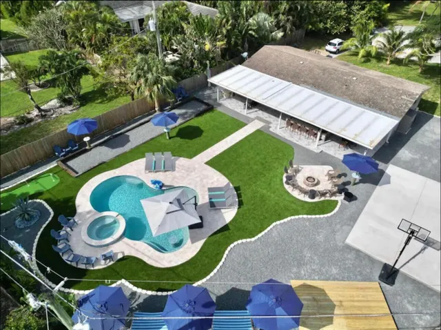 a view of a swimming pool with a table and chairs under an umbrella