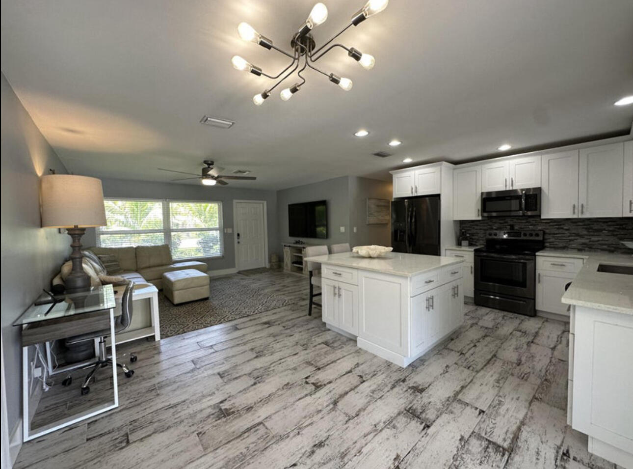 270 Northwest 36th Street Boca Raton, FL 33431 - Photo 56 of 82 a kitchen with a stove a refrigerator a sink dishwasher with a dining table and chairs