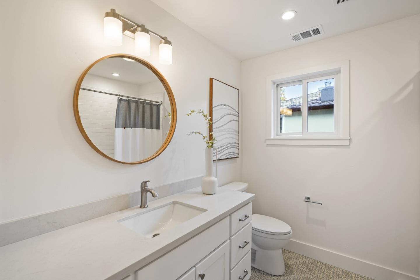 1642 Anamor Street Redwood City, CA 94061 - Photo 11 of 19 a bathroom with a toilet a sink a mirror and a window