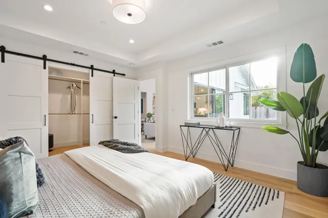 a bedroom with a bed and a potted plant