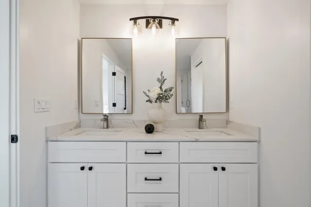 a bathroom with double vanity sinks and a mirror