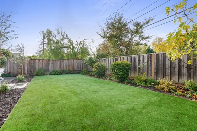 a view of a backyard with potted plants and wooden fence
