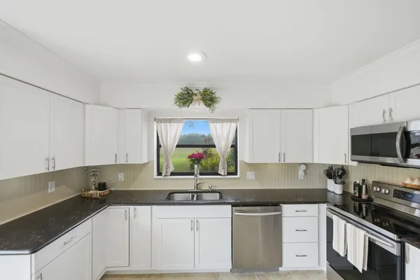 a kitchen with stainless steel appliances granite countertop a sink and a stove