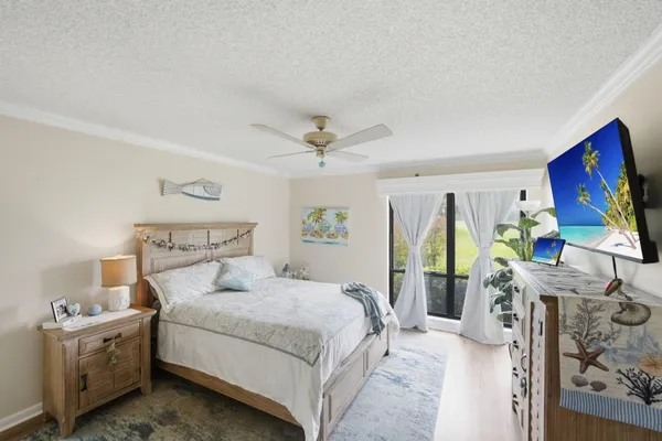 a bedroom with a bed table chair and a window