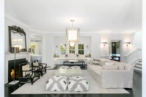 a living room with furniture fireplace and large windows