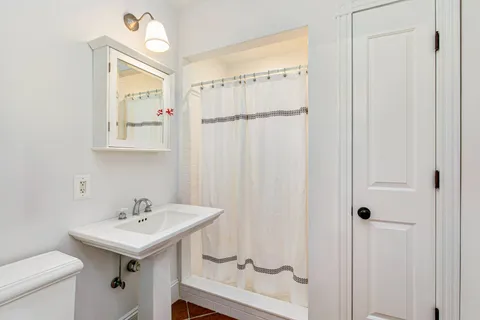 a bathroom with a sink a toilet and shower