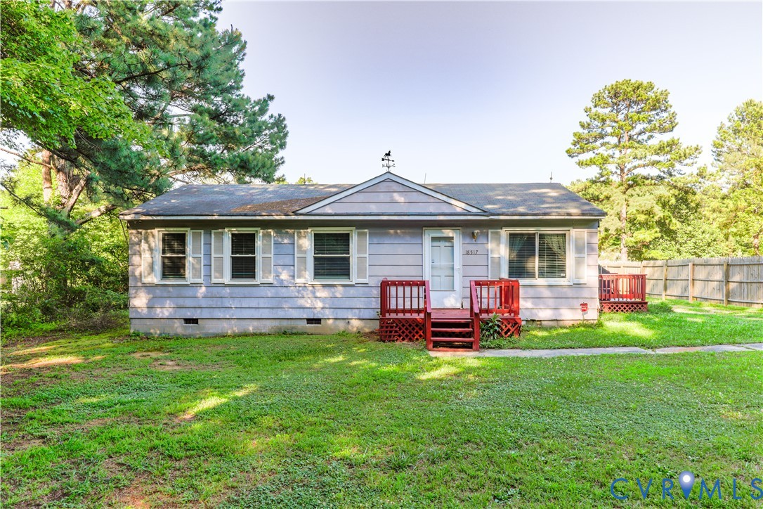 a front view of a house with a garden and trees