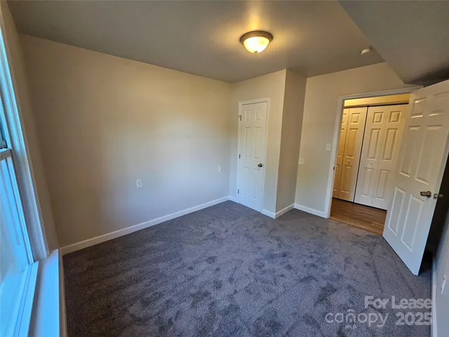an empty room with wooden door and fan
