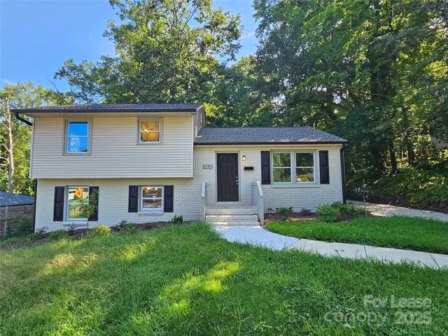a front view of a house with a garden and yard