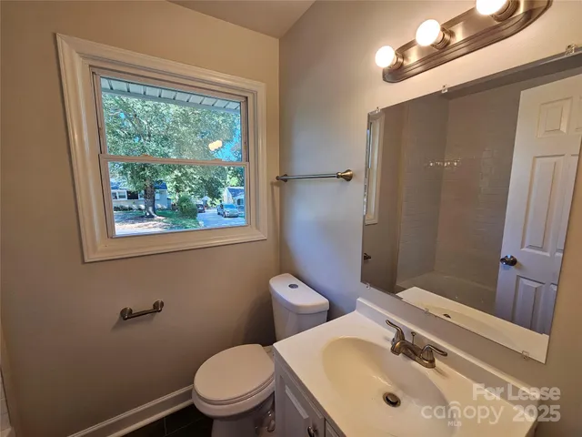 a bathroom with a sink a toilet and a mirror