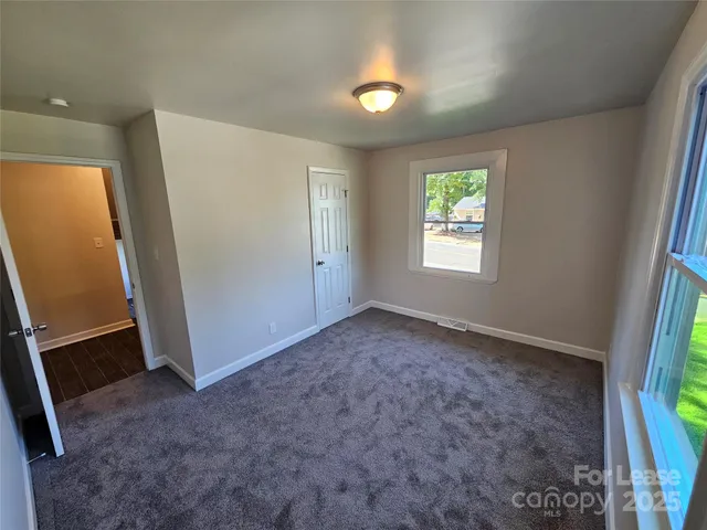 an empty room with windows and closet