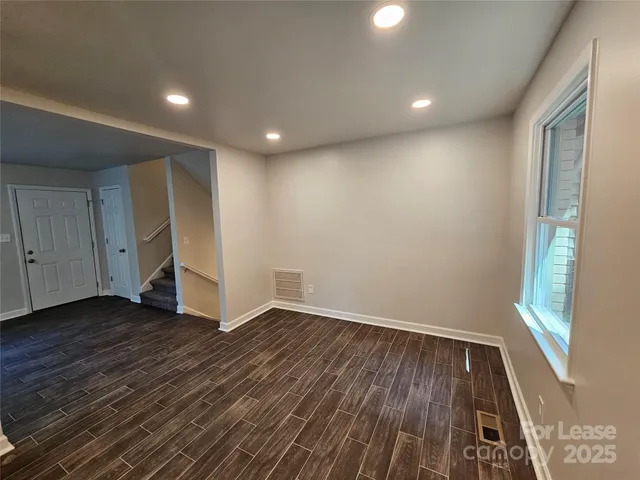 a view of an empty room with wooden floor and closet