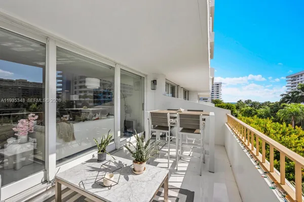 a balcony with furniture and a floor to ceiling window