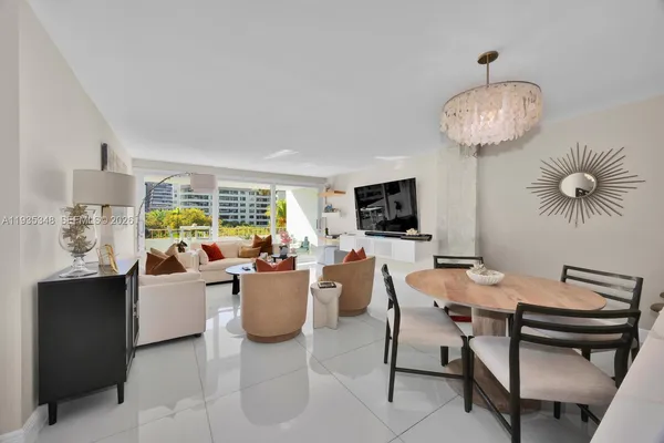 a living room with furniture a chandelier and a flat screen tv