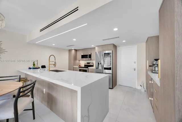 a kitchen with a sink a counter top stainless steel appliances and cabinets
