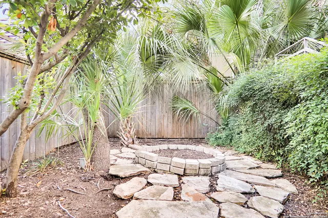 a view of a patio with table and chairs with wooden floor and fence and trees