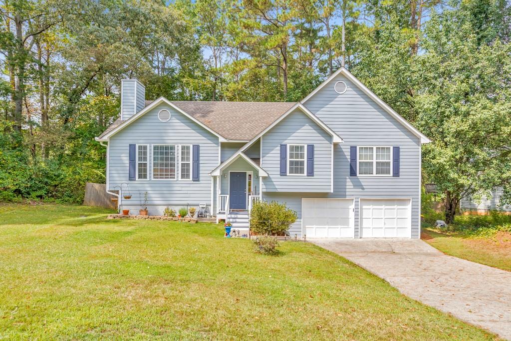 a front view of a house with a garden and trees
