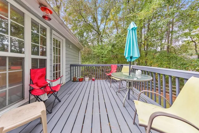 a balcony with wooden floor and outdoor seating