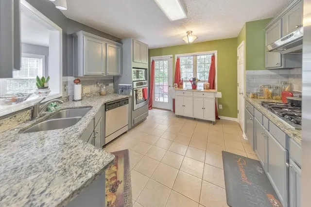 a large kitchen with stainless steel appliances granite countertop a stove a sink and a granite counter tops