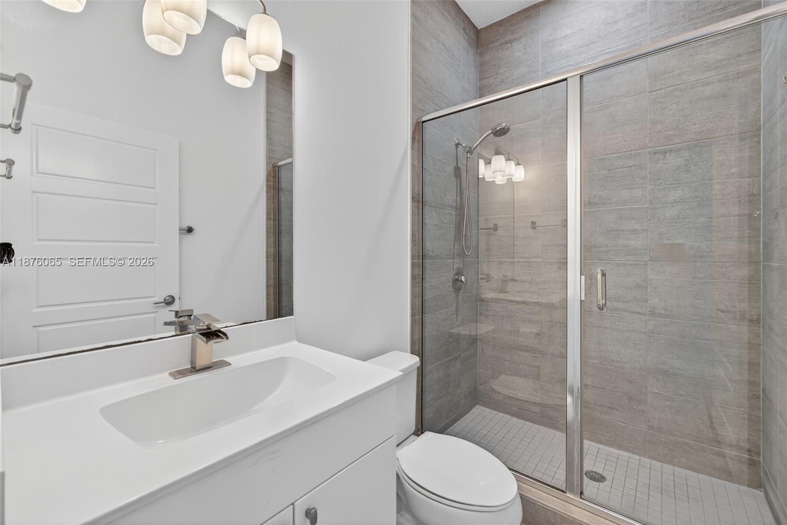 17606 Southwest 149th Place, Unit 17606 Miami, FL 33187 - Photo 19 of 69 a bathroom with a sink a toilet and shower