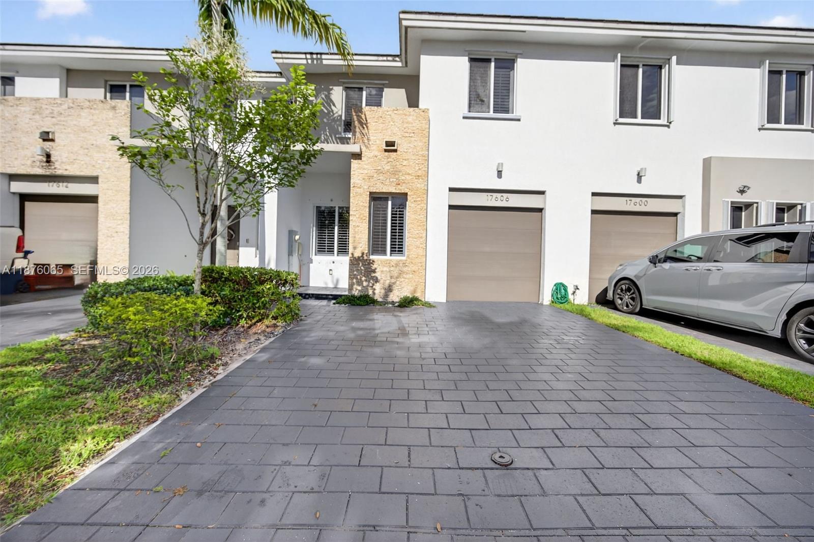 17606 Southwest 149th Place, Unit 17606 Miami, FL 33187 - Photo 2 of 69 a front view of a house with a yard and a garage