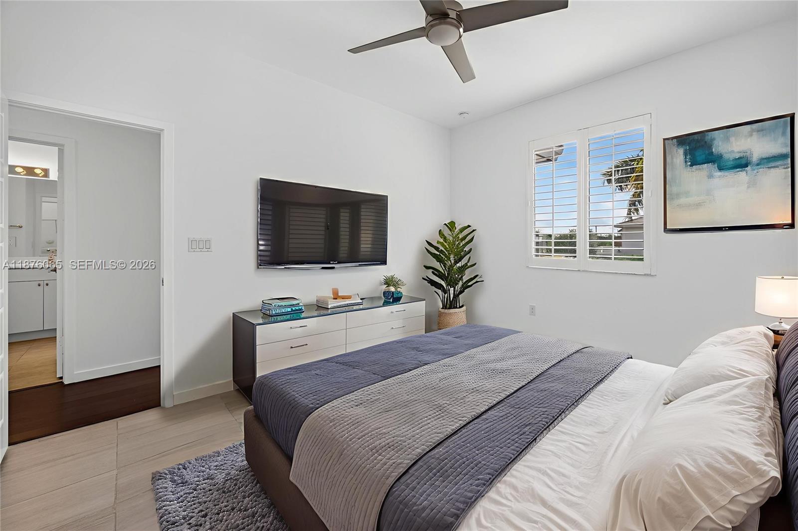17606 Southwest 149th Place, Unit 17606 Miami, FL 33187 - Photo 49 of 69 a bedroom with a bed and a flat screen tv
