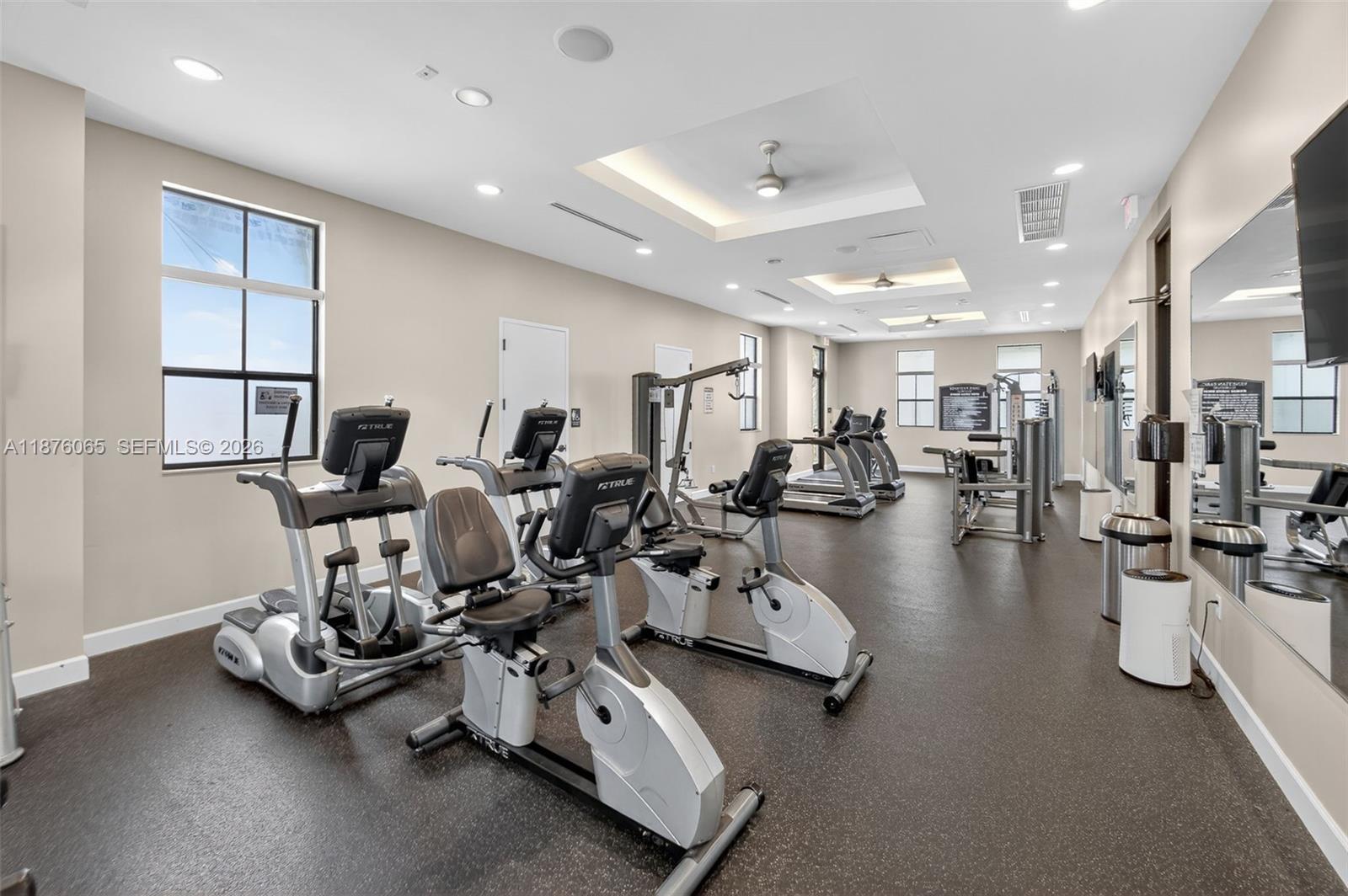 17606 Southwest 149th Place, Unit 17606 Miami, FL 33187 - Photo 65 of 69 a room with gym equipment and a view of living room